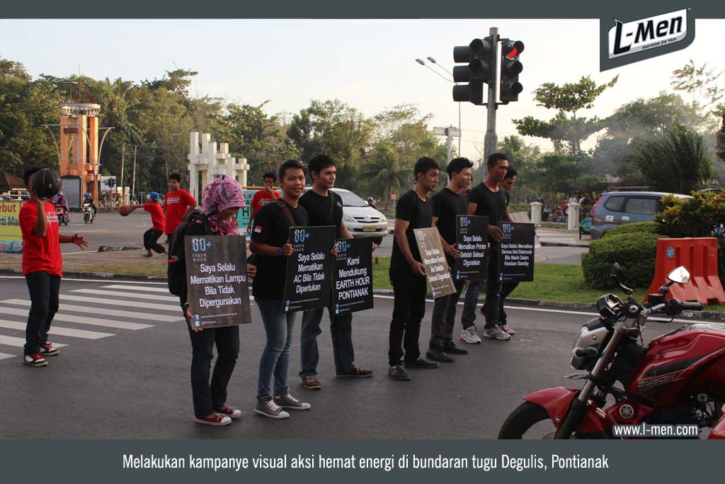 Melakukan kampanye visual aksi hemat energi di bundaran tugu Degulis, Pontianak