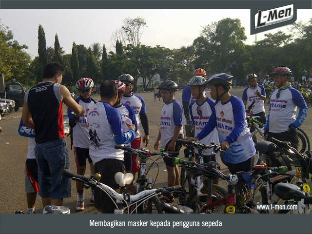 Membagikan masker kepada pengguna sepeda